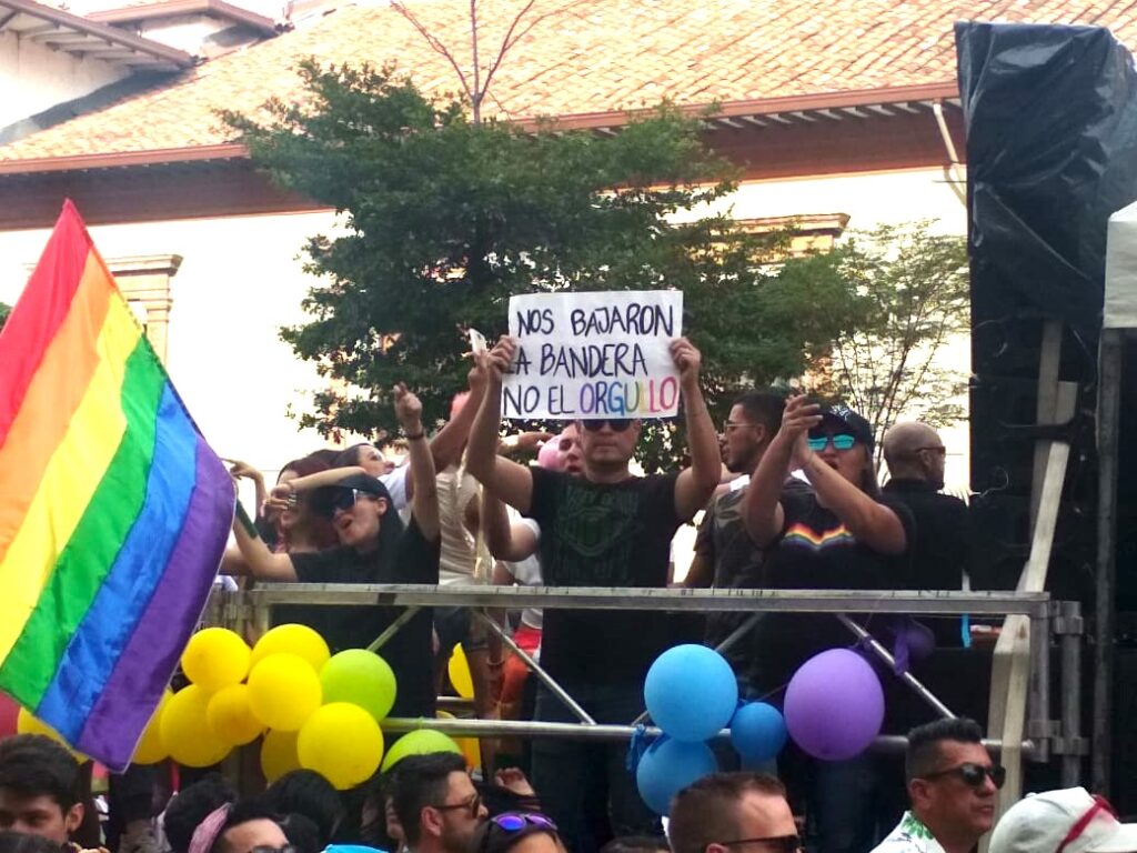 At Medellin Gay Pride a man holds a sign.