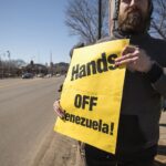 Protester holds sign opposing US intervention in Venezuela